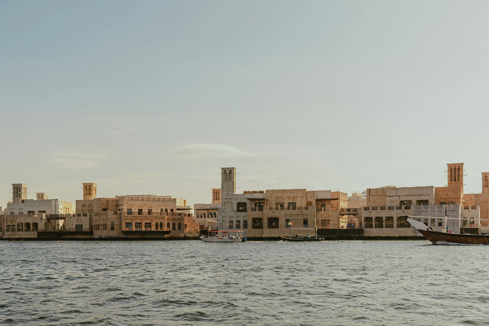 Traditional wind towers and boats along Dubai Creek in the United Arab Emirates